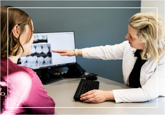 dentist pointing at x-ray during meeting with patient