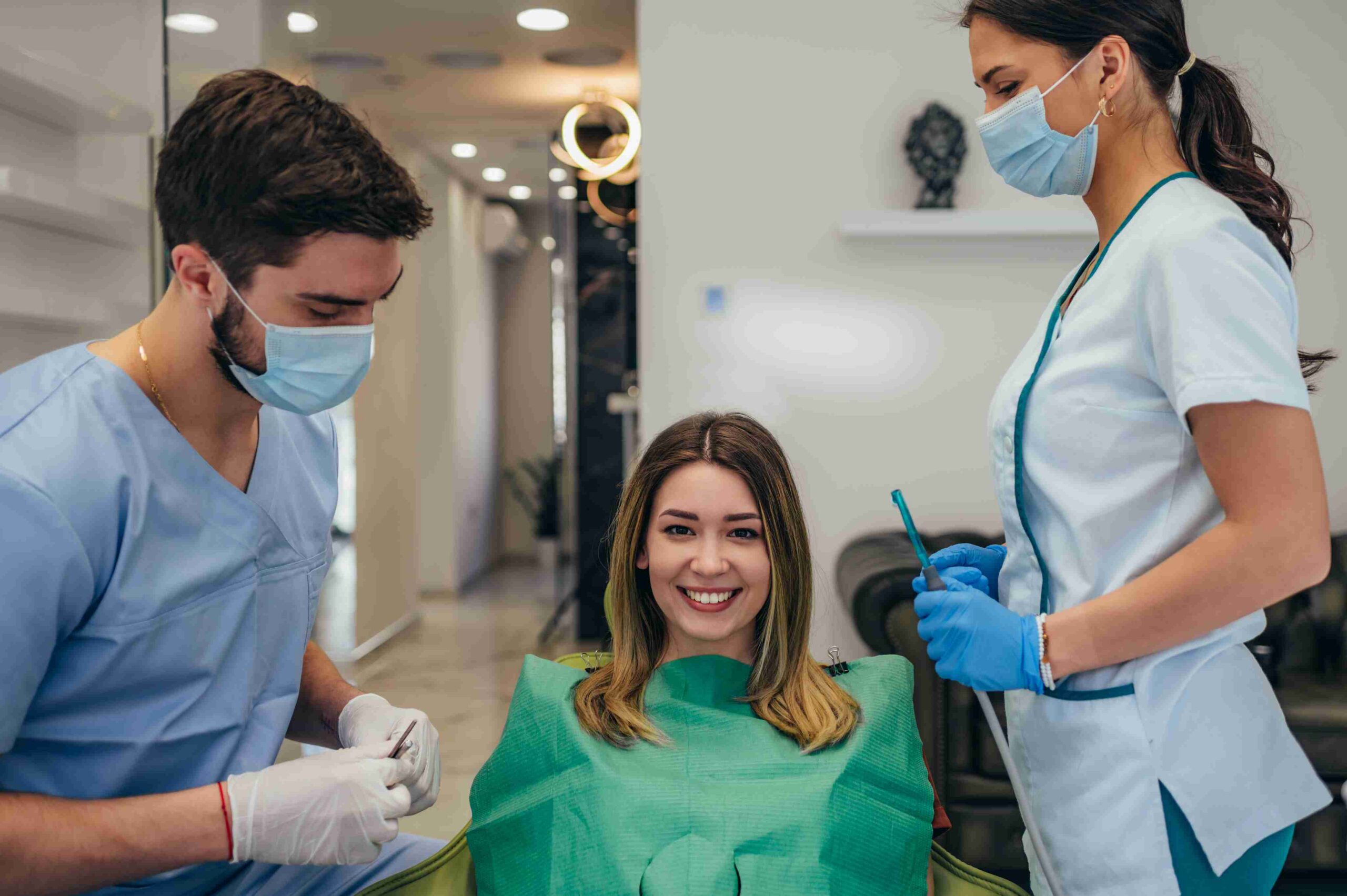 Smiling patient with dental care team during treatment.